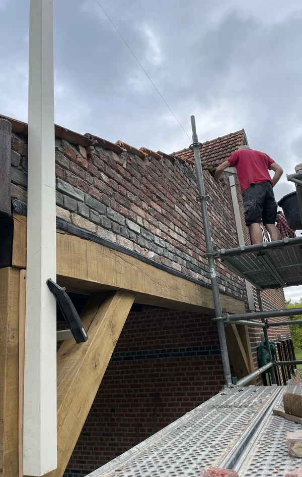 Gunther metselt ambachtelijk de muur opnieuw op na plaatsing van nieuwe eikenhouten draagbalk in Grootlo door NSS-Constructie