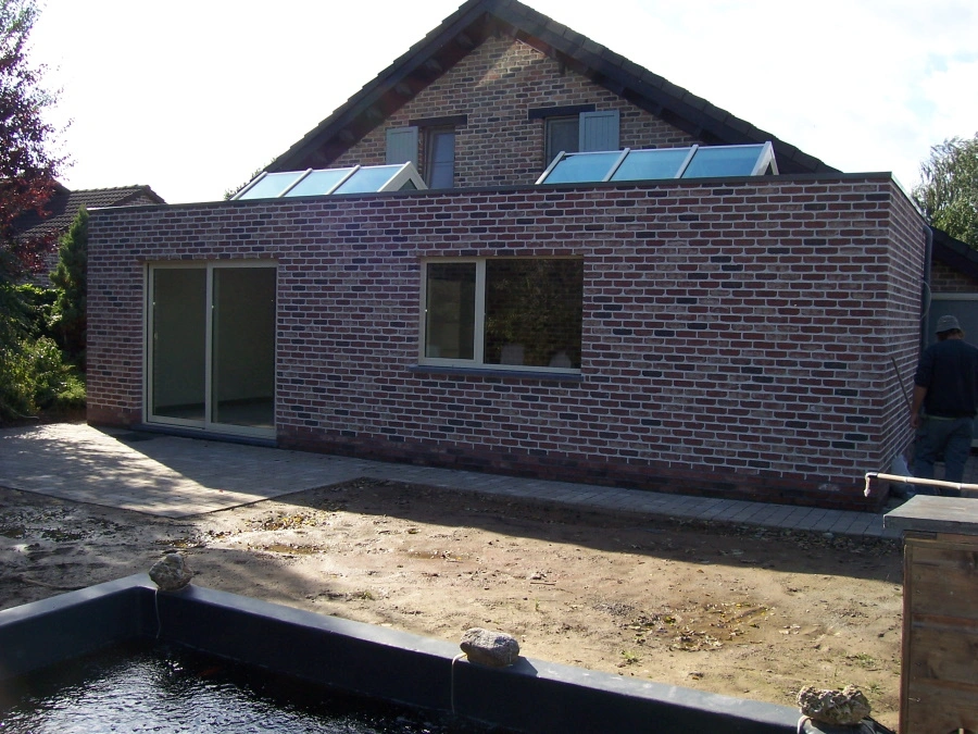 Afgewerkte moderne aanbouw met dakkoepels in Tremelo voor extra natuurlijk licht door NSS-Constructie