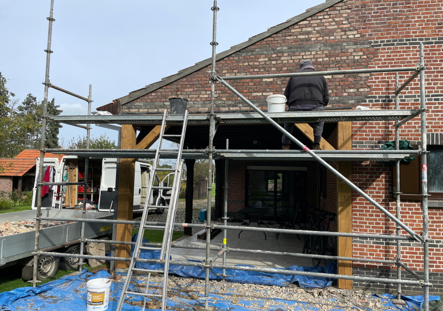 Sven voegt ambachtelijk de opnieuw opgebouwde muur tijdens renovatie in Grootlo door NSS-Constructie